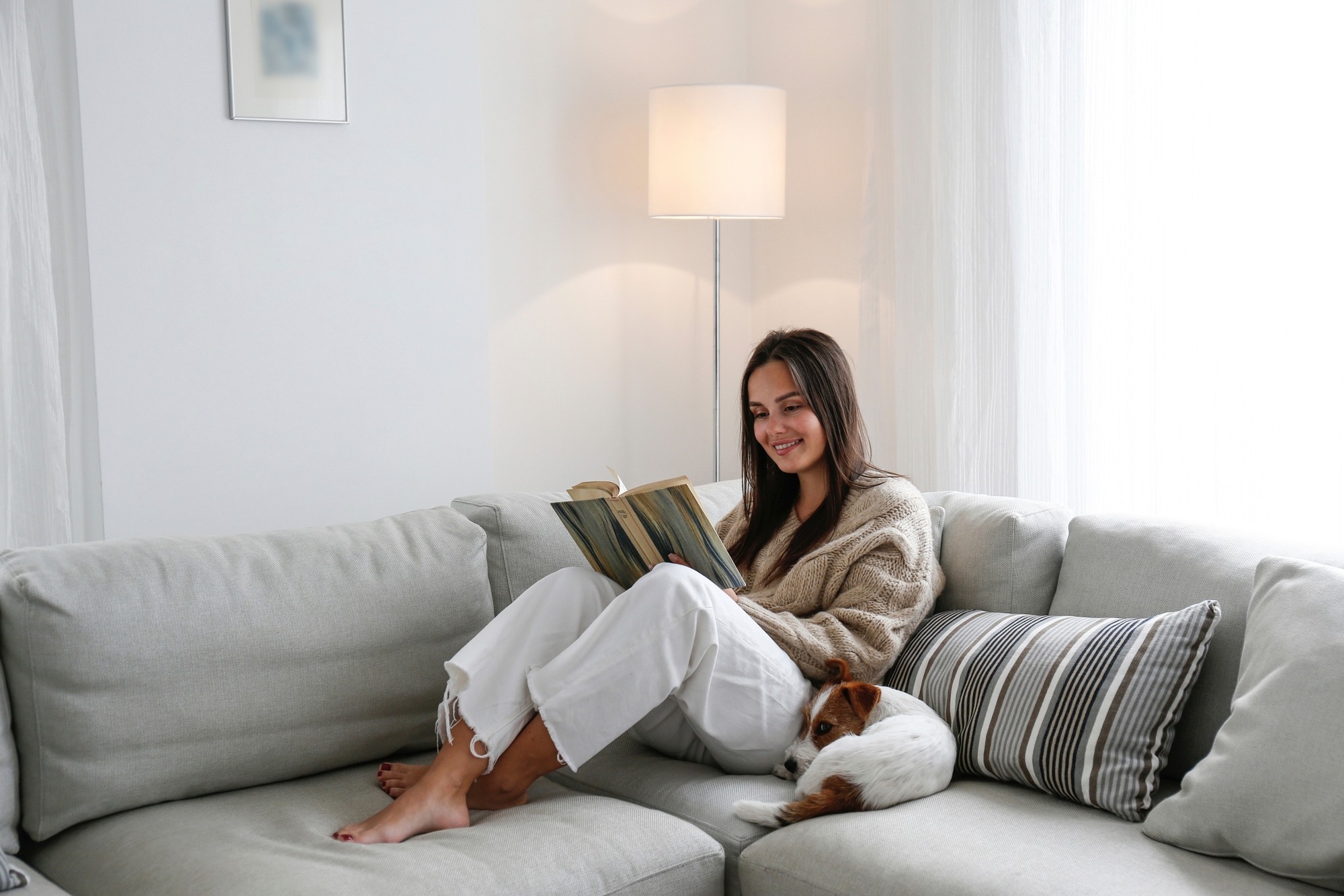 A Woman Reading a Contemporary Adult Fiction Novel on a Couch